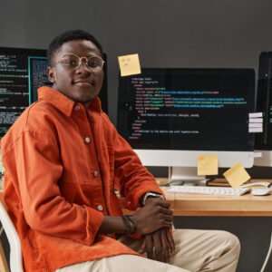 Young IT support manager looking at camera while sitting by workplace Young IT support manager looking at camera while sitting by workplace